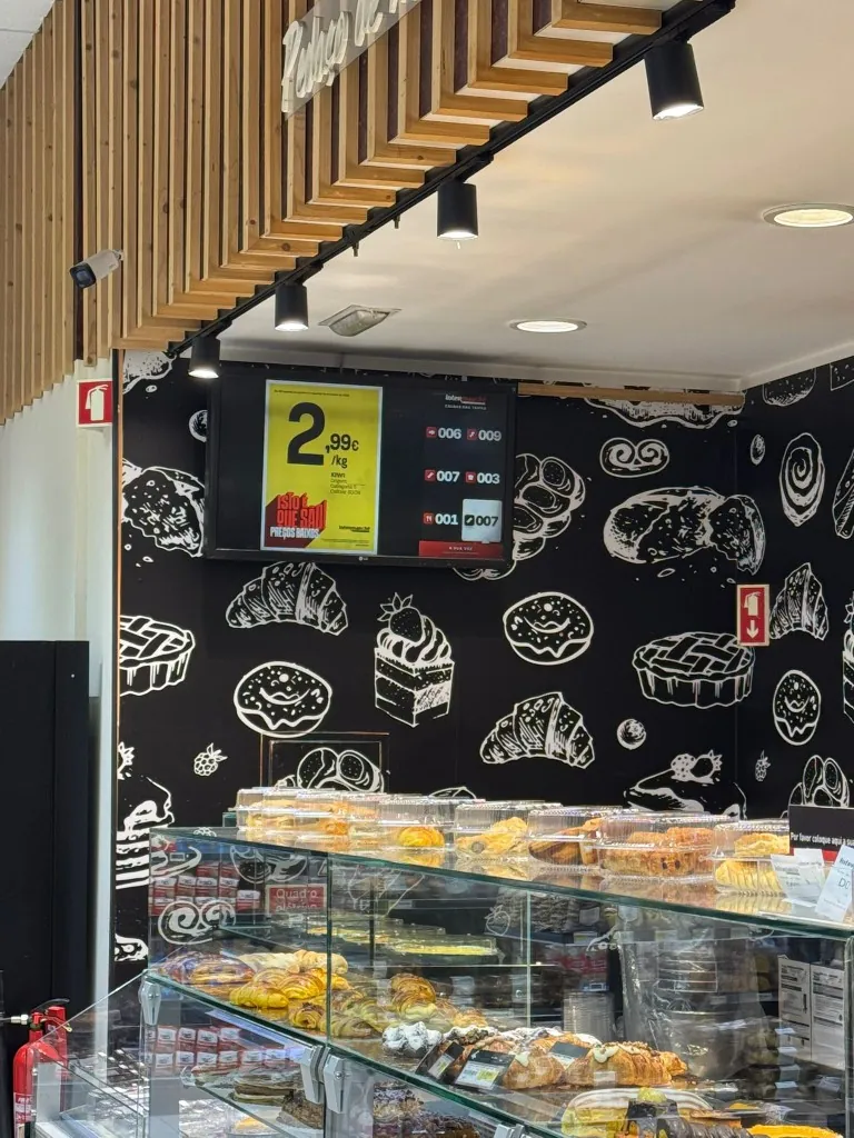 Ecrã LCD de menu e senhas numa padaria após conversão