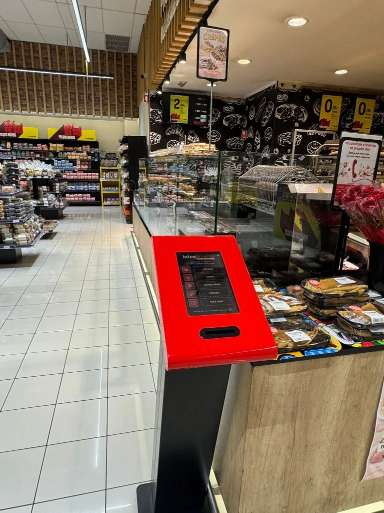 Dispensador de senhas em supermercado após conversão do sistema de filas