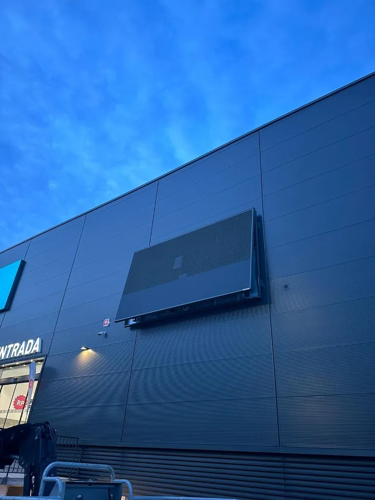 Painel LED em fachada com falha de imagem durante reparação